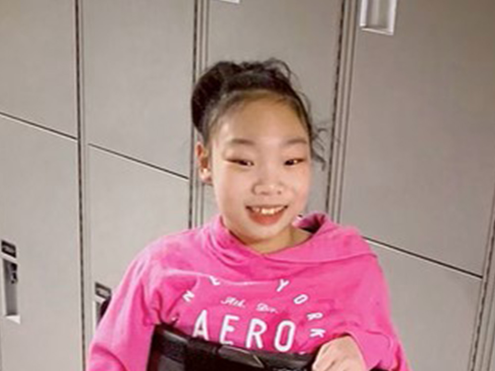 child in standing frame in front of school lockers