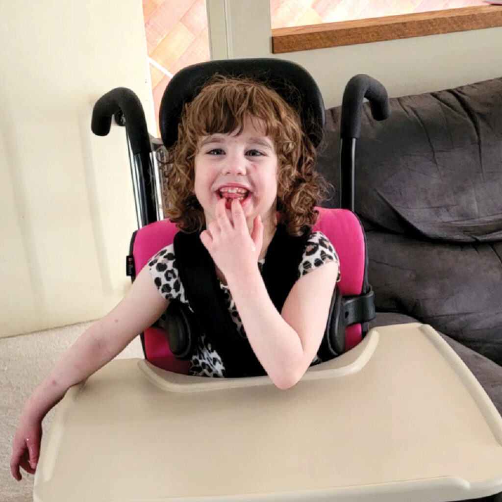 smiling child in specialized activity chair