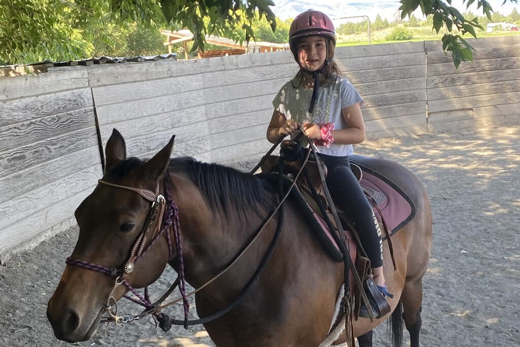 Evelyn girl riding a horse during an equine therapy session